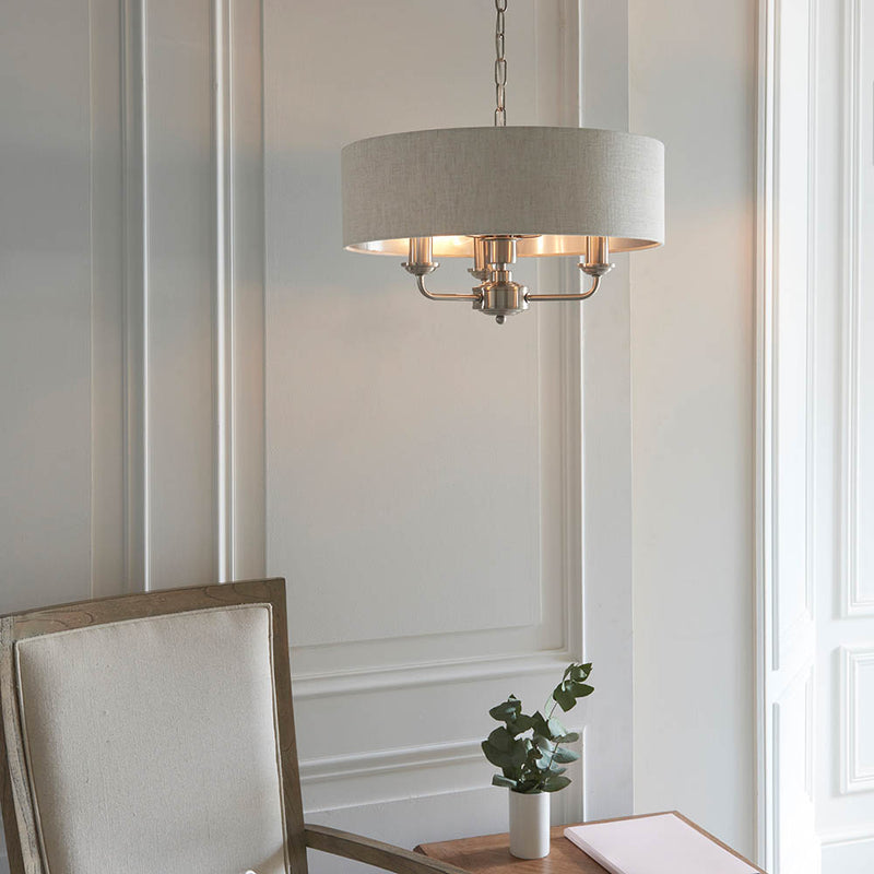Highclere 3 Light Drum Pendant lit up in a styled bedroom