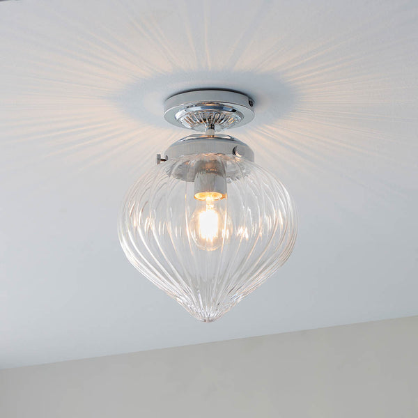 Cheston Bathroom Flush Ceiling Light lit up in a styled bathroom