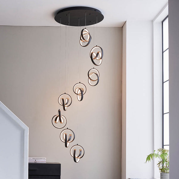 Cosma 8 Light LED Cluster Pendant in textured black hanging in a stairwell