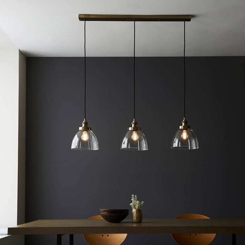 Hansen 3 Light Linear Pendant in antique brass shown in a room setting