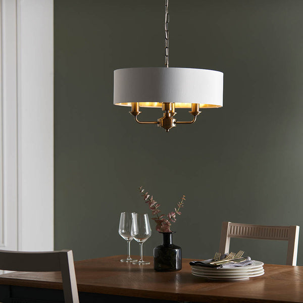Highclere 3 Light Drum Pendant in antique brass shown in a room setting