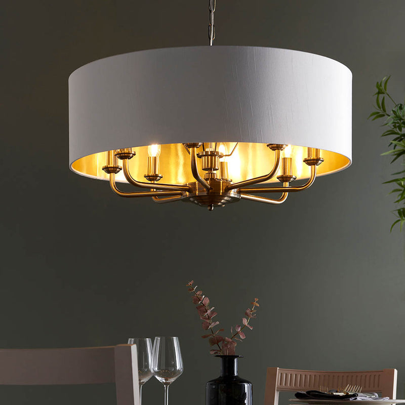 Highclere 8 Light Drum Pendant in antique brass hanging in a living room