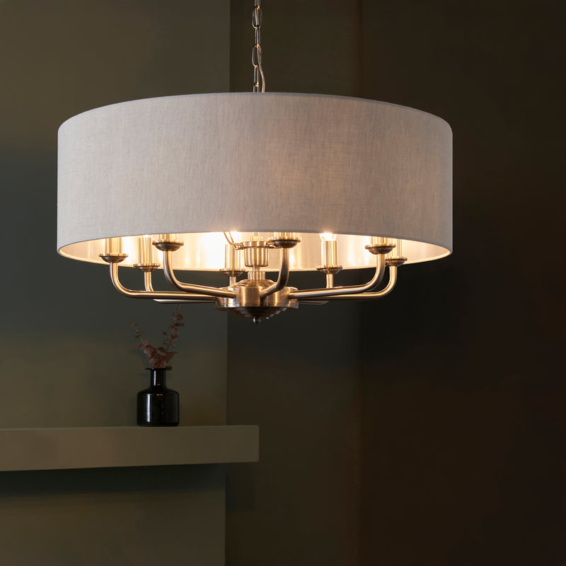 Highclere 8 Light Drum Pendant lit up in a styled living room