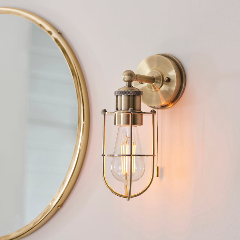 Crew Bathroom Wall Light in antique brass on a wall