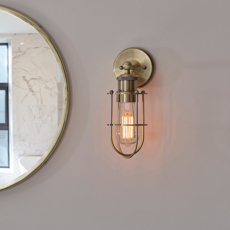 Crew Bathroom Wall Light in antique brass shown in a room setting