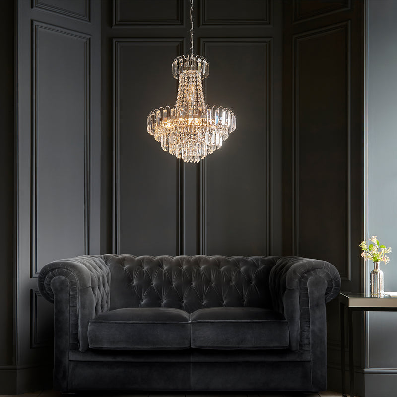 Amadis 6 Light Pendant illuminated against dark panelled wall