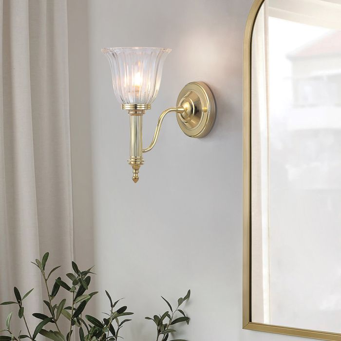 Elstead Carroll 1 Light Wall Light in polished brass with a solid brass body and elegant finish. IP44-rated for bathroom use, includes a 3W LED G9 bulb. Provides warm 3000K illumination with a stylish design.