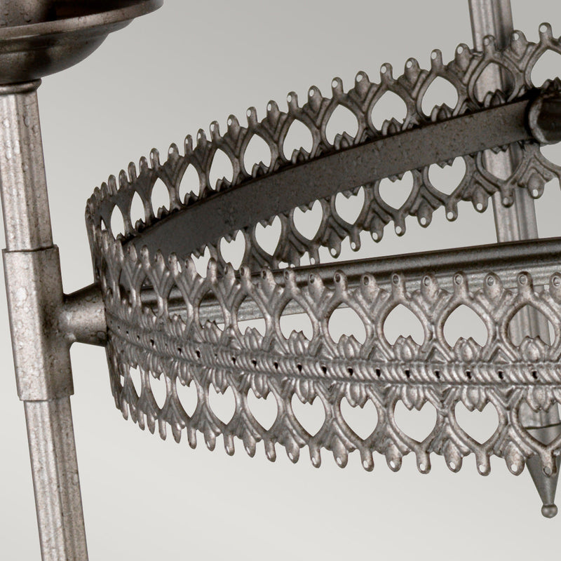 This Elstead Crown 6 light chandelier ceiling light in iron gate finish is traditional and rustic. Featuring a ceiling mount, chain suspension and central rod, with filigree metalwork rim and curving arms attached to tall candle style lights.