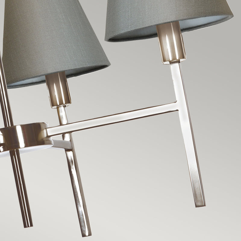 This Elstead Lucerne 4 light chandelier in brushed nickel finish with grey shades is sleek and contemporary. Featuring a ceiling mount, chain suspension, and drop rod, with a lower gallery and four straight arms, with upright stems, bright nickel lamp holders, and grey cone shades. Ideal for a bright and airy dining room, hallway, bedroom, or living room ceiling.