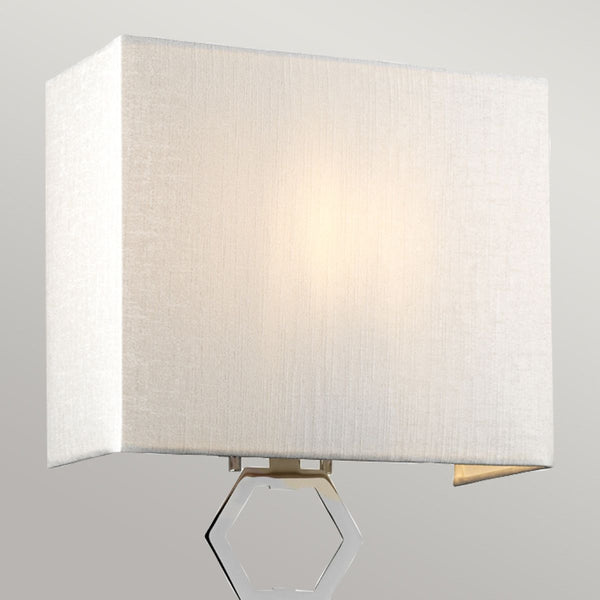Elstead Ria Medium 1 Light Wall Light in polished chrome with a handcrafted ivory faux silk shade. Features an elegant octagonal finial and dimmable functionality for sophisticated interiors.
